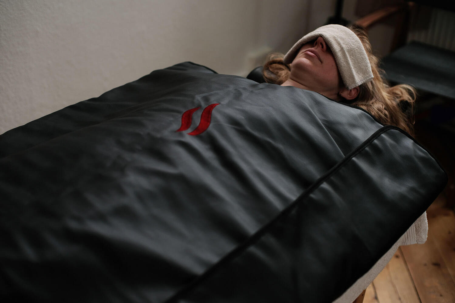 Behandling med saunatæppe i afslappende omgivelser